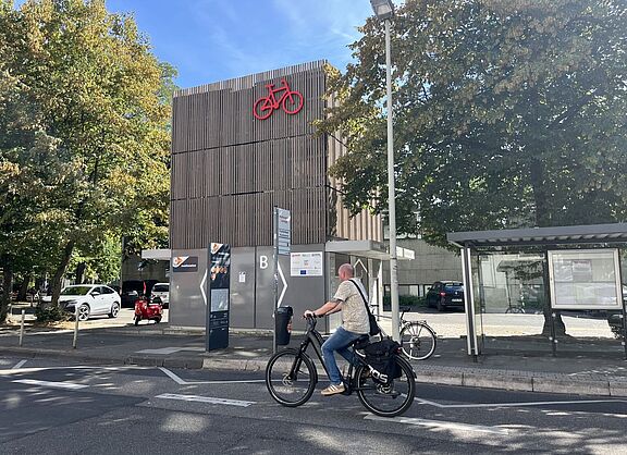 Fahrradparkhaus mit Fahrradfahrer am Eingang